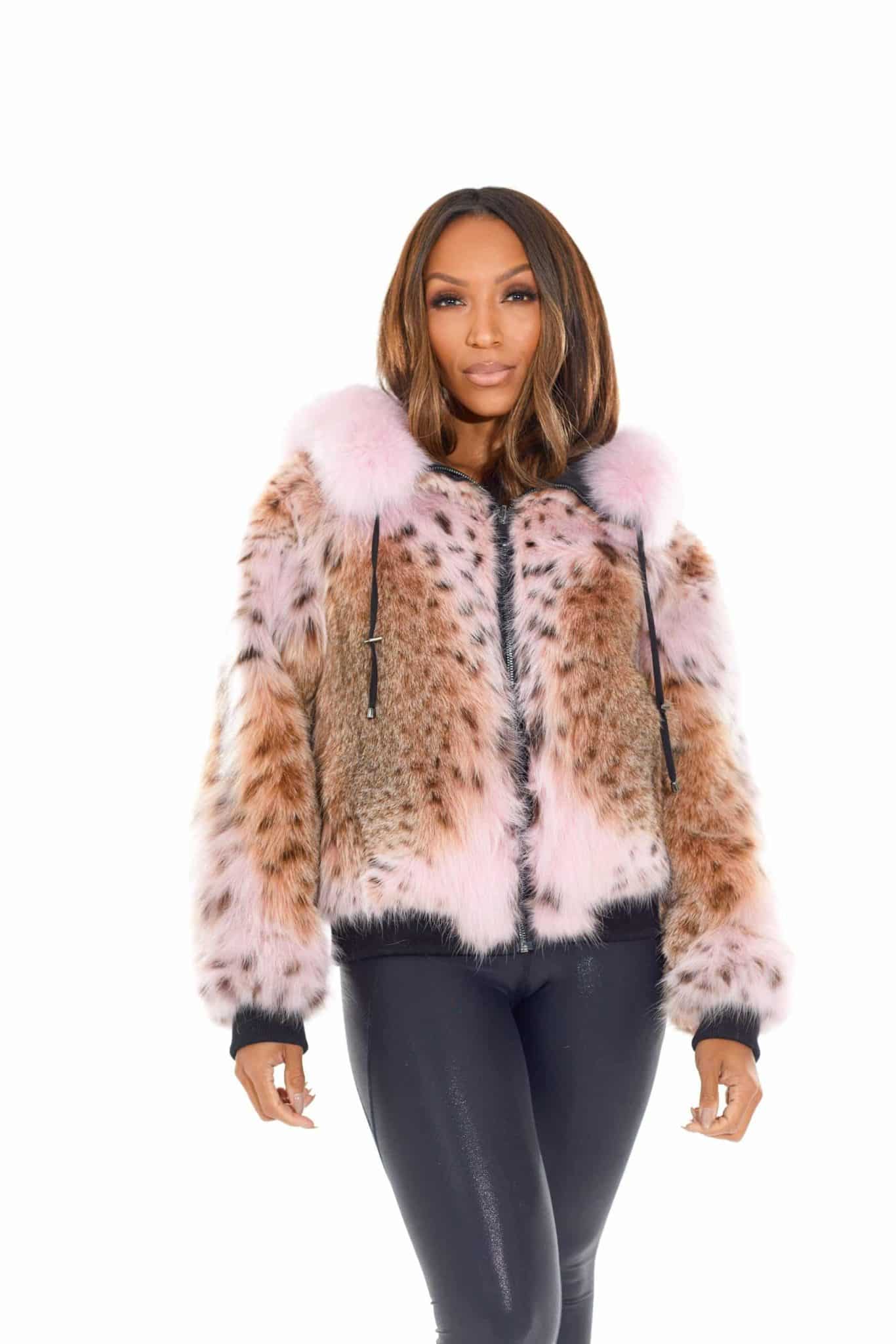 Frontal view of a woman in a fur coat standing in front of a white background. The coat is zipped up and the woman's arms are at her sides.