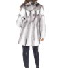 Rear view of a woman wearing a cross mink fur stroller facing a white background.