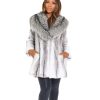Frontal view of a woman wearing a cross mink fur stroller standing in front of a white background.