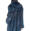 Rear view of a woman wearing a cross mink fur stroller facing a white background.