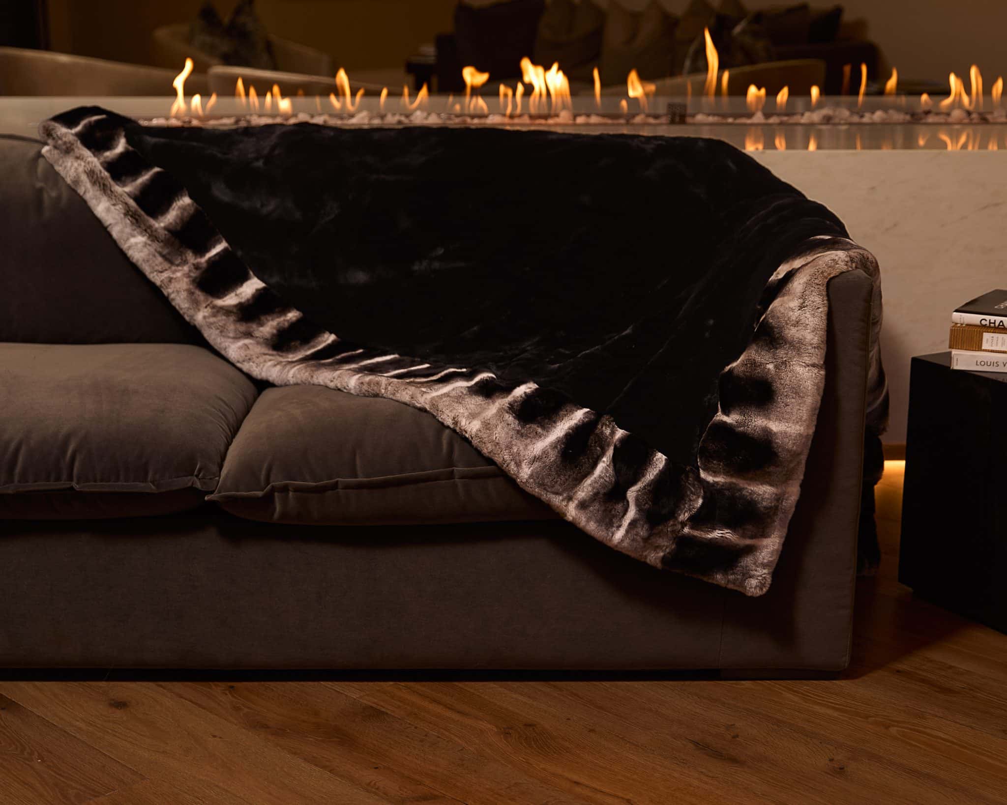 Onyx Chinchilla Rex Blanket draped over couch