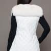 SFGPHOTOPIADAY1_LOOK40_0107 Rear view of a woman in a white fox pelt vest facing a grey background