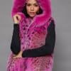 SFGPHOTOPIADAY2_LOOK120 Frontal view of a woman in a pink lynx fur vest with the hood up standing in front of a grey background
