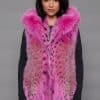 SFGPHOTOPIADAY2_LOOK1201 Frontal view of a woman in a pink lynx fur vest with the hood down standing in front of a grey background