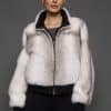 ATHANASIA CROSS MINK JACKET FRONT Frontal view of a woman in a white jacket against a grey background