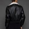 ATHANASIA CROSS MINK JACKET REV BACK the back of a woman in a black leather jacket against a grey background