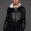 ATHANASIA CROSS MINK JACKET REV FRONT woman in a black leather jacket against a grey background