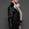 ATHANASIA CROSS MINK JACKET REV SIDE the side of a woman in a black leather jacket against a grey background