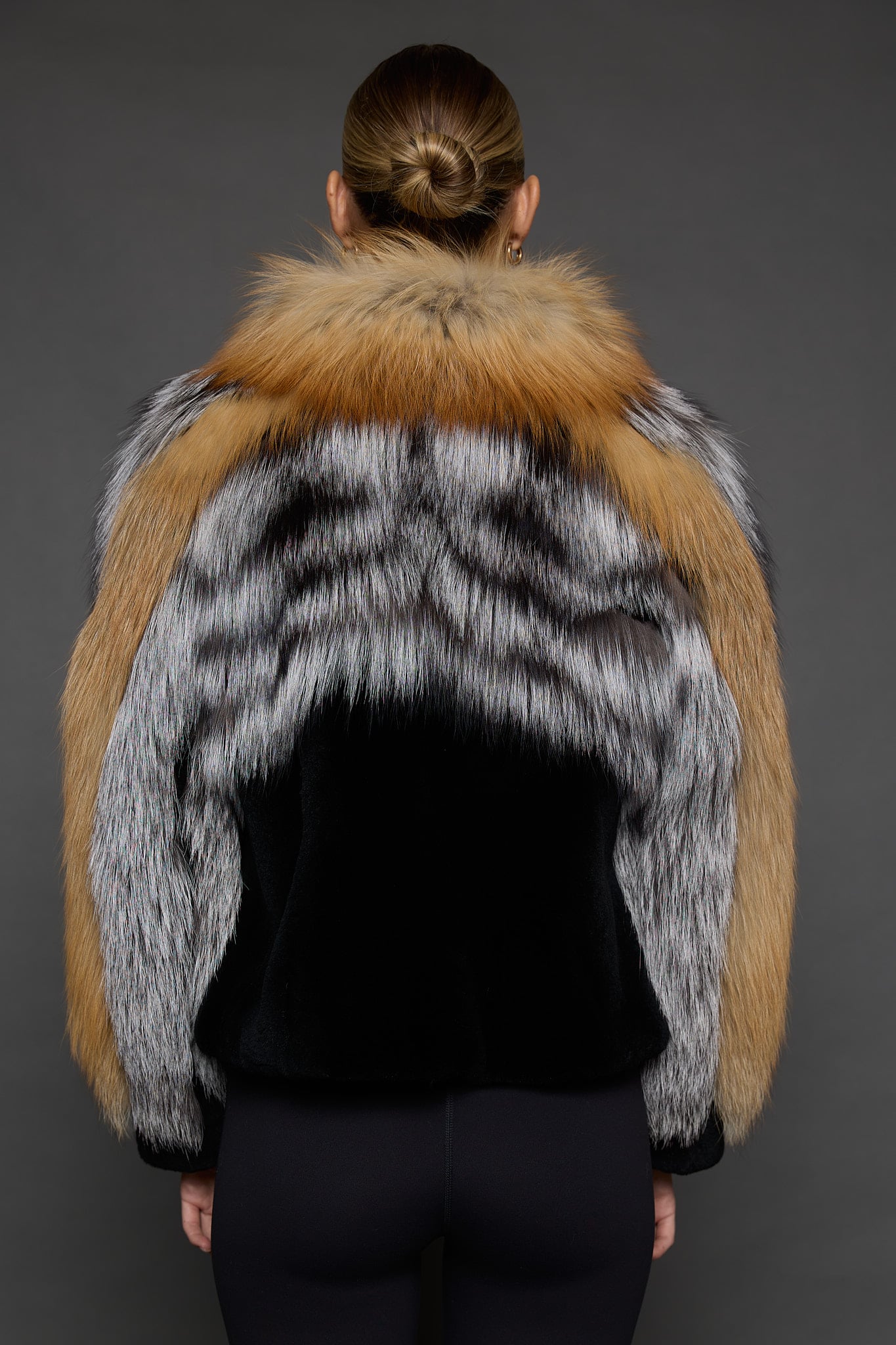 CAMILLA RED FOX JACKET BACK 2 the back of a woman in a red and black jacket against a grey background