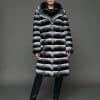 ECOMMWOMENS20255567 Frontal view of a woman in a natural empress chinchilla coat with her arms at her side standing in front of a grey background.