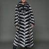 ECOMMWOMENS20255580 Frontal view of a woman in a natural chinchilla full length coat that is closed, standing against a grey background
