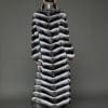 ECOMMWOMENS20255584 Rear view of a woman in a natural chinchilla full length coat, facing a grey background