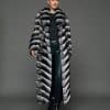 ECOMMWOMENS20255591 Frontal view of a woman in a natural chinchilla full length coat that is open, standing against a grey background