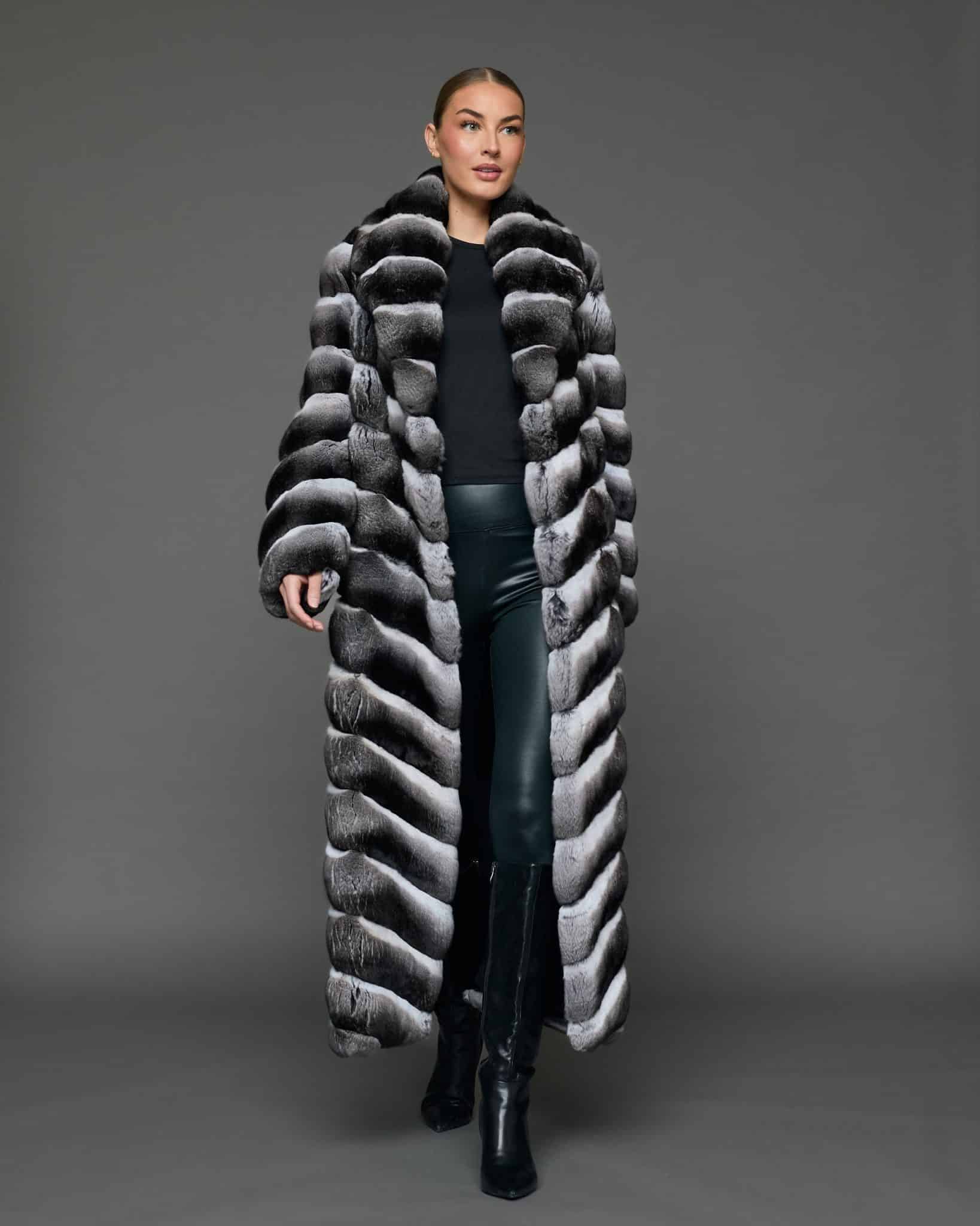 ECOMMWOMENS20255591 Frontal view of a woman in a natural chinchilla full length coat that is open, standing against a grey background