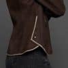 IMANI BROWN TAN JACKET DETAIL up close shot of a woman in a dark brown jacket against a grey background