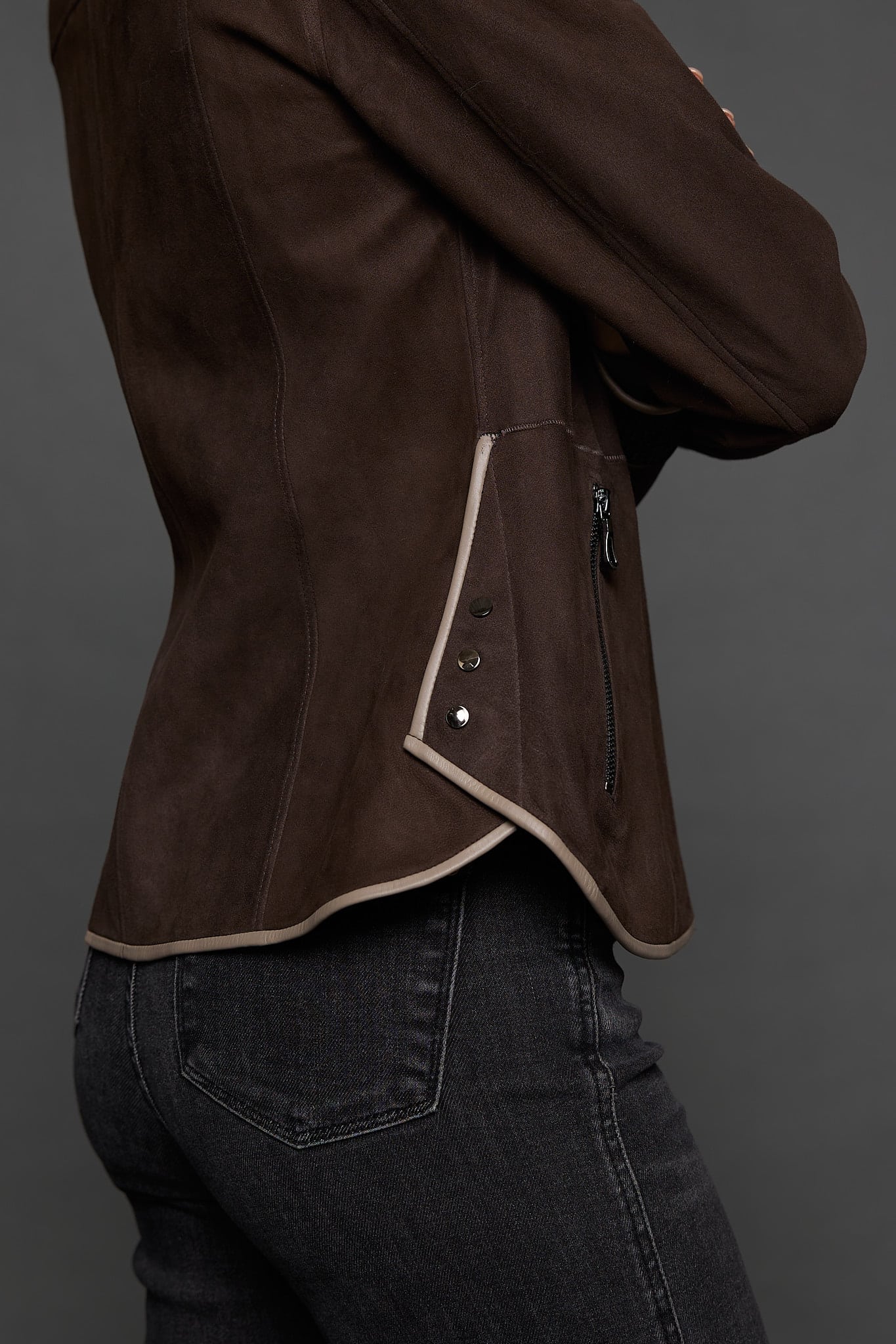 IMANI BROWN TAN JACKET DETAIL up close shot of a woman in a dark brown jacket against a grey background
