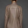 IMANI BROWN TAN JACKET REV BACK the back of a woman in a light brown leather jacket against a grey background