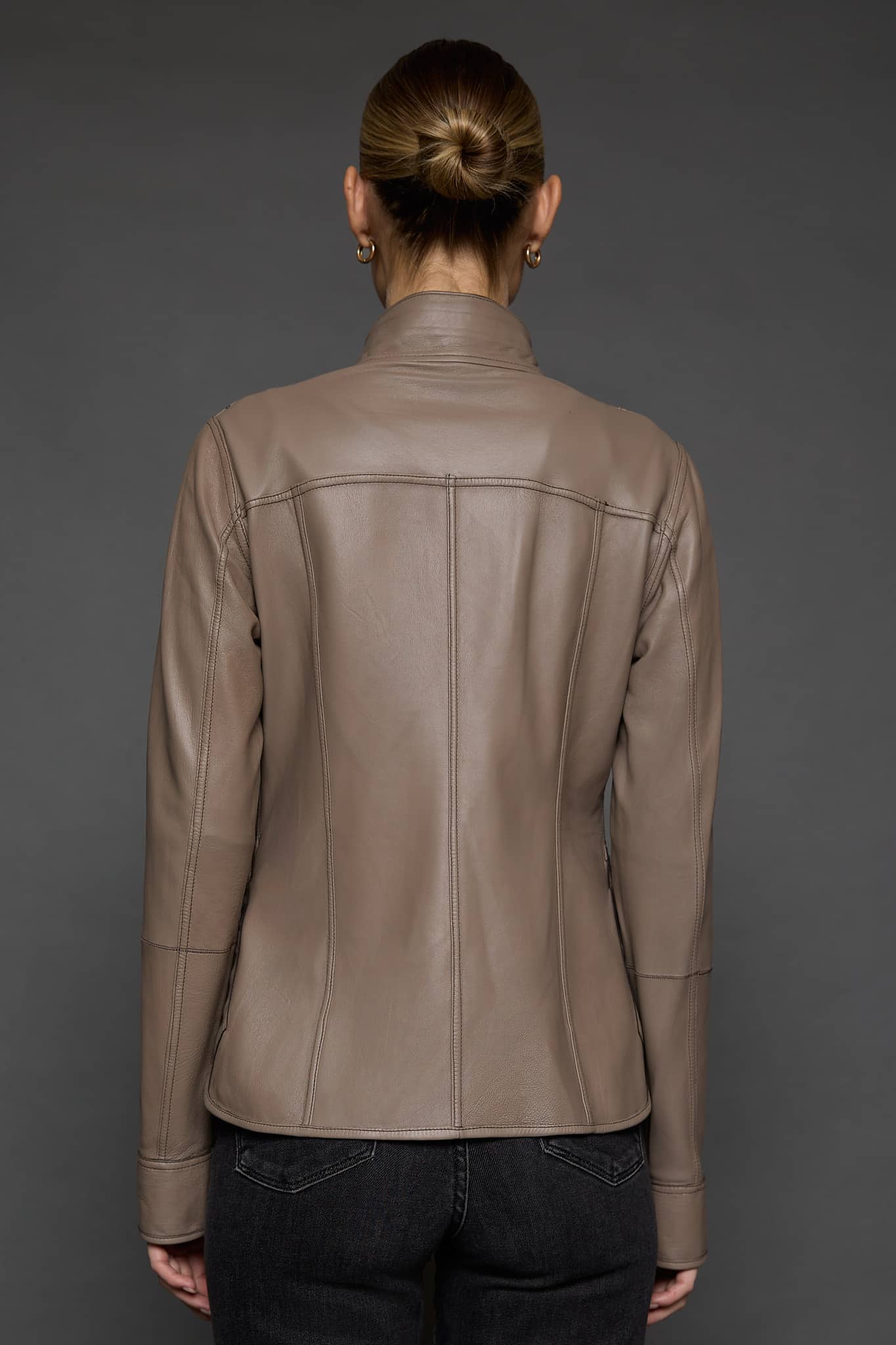 IMANI BROWN TAN JACKET REV BACK the back of a woman in a light brown leather jacket against a grey background