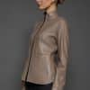 IMANI BROWN TAN JACKET REV SIDE the side of a woman in a light brown leather jacket against a grey background