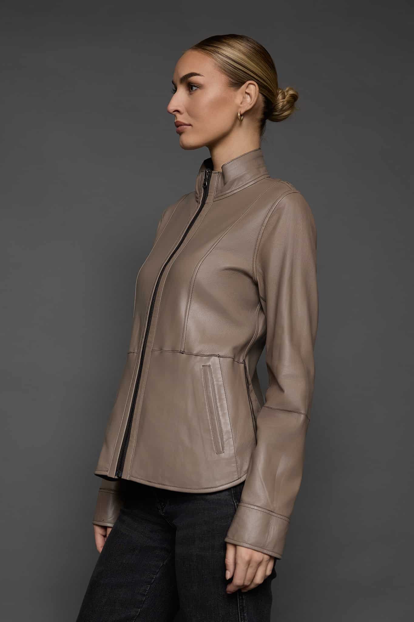 IMANI BROWN TAN JACKET REV SIDE the side of a woman in a light brown leather jacket against a grey background
