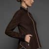 IMANI BROWN TAN JACKET SIDE the side of a woman in a dark brown jacket against a grey background