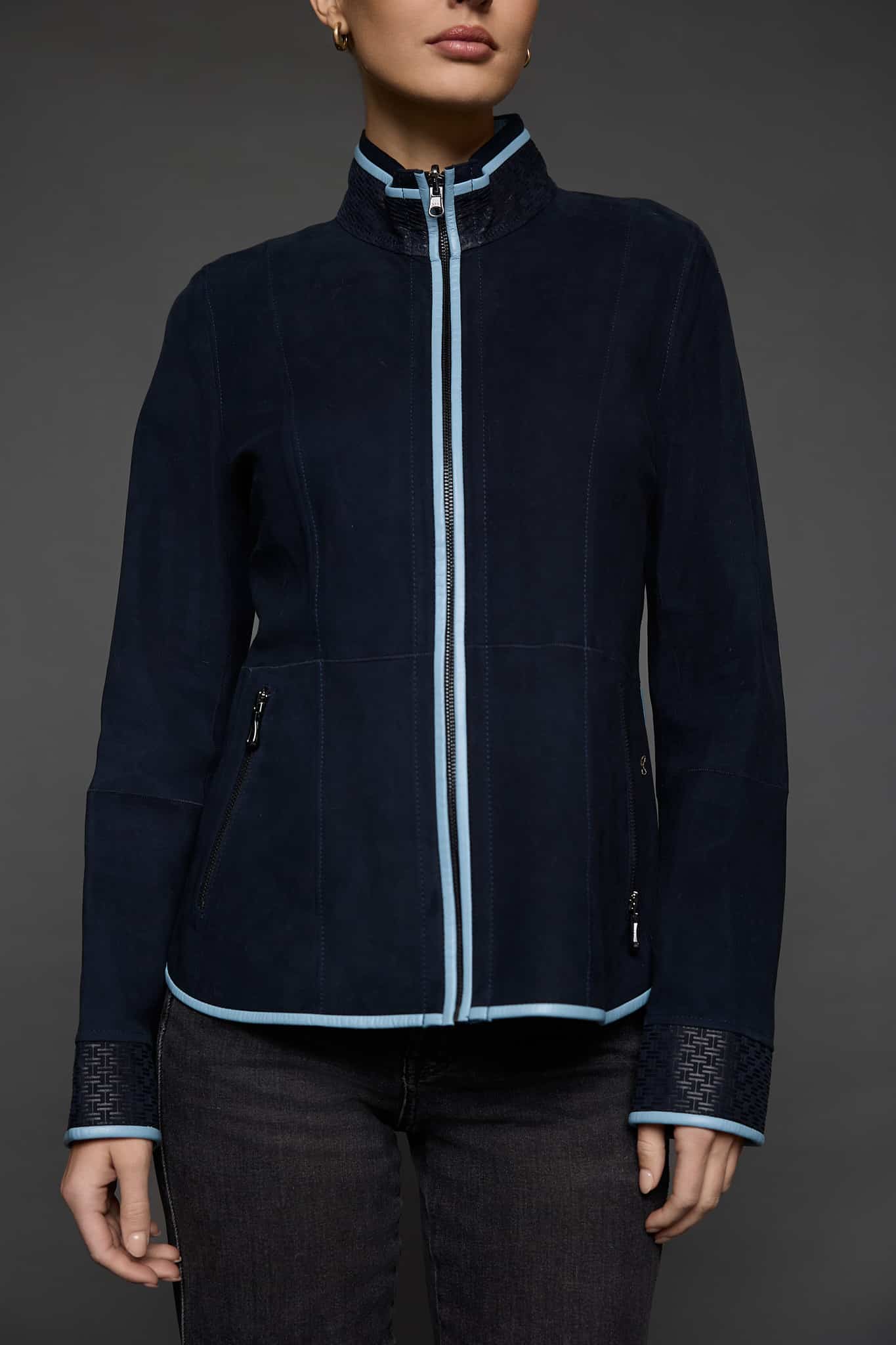 IMANI NAVY BLUE JACKET DETAILS bodice shot of a woman in a dark blue jacket against a grey background