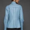 IMANI NAVY BLUE JACKET REV BACK the back of a woman in a light blue jacket against a grey background