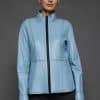 IMANI NAVY BLUE JACKET REV FRONT woman in a light blue jacket against a grey background