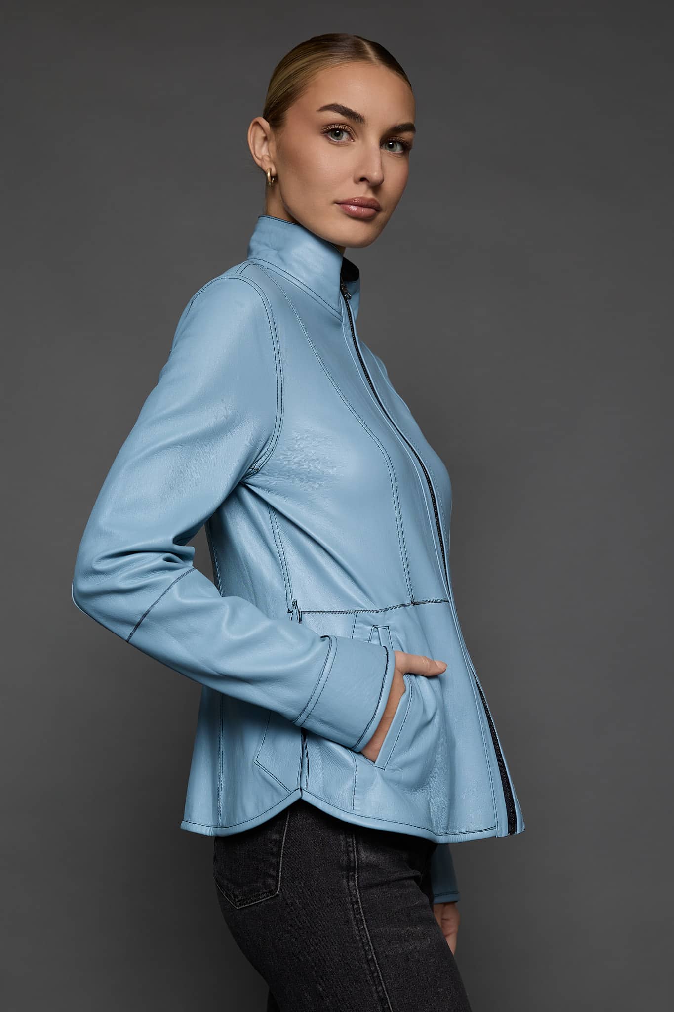 IMANI NAVY BLUE JACKET REV SIDE the side of a woman in a light blue jacket against a grey background