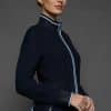 IMANI NAVY BLUE JACKET SIDE the side of a woman in a dark blue jacket against a grey background