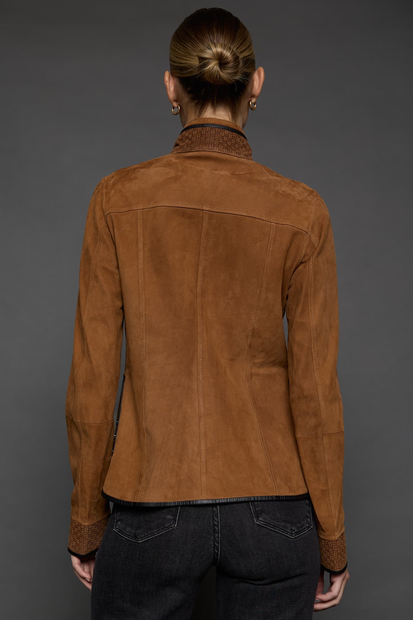 IMANI SNUFF BLACK JACKET BACK the back of a woman in a tan jacket against a grey background