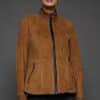 IMANI SNUFF BLACK JACKET FRONT woman in a tan jacket against a grey background