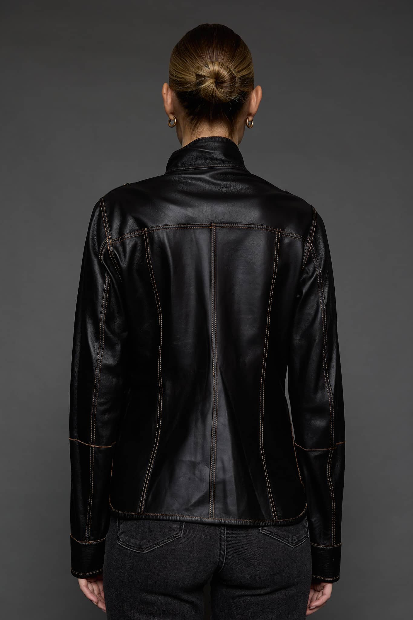 IMANI SNUFF BLACK JACKET REV BACK the back of a woman in a black jacket against a grey background