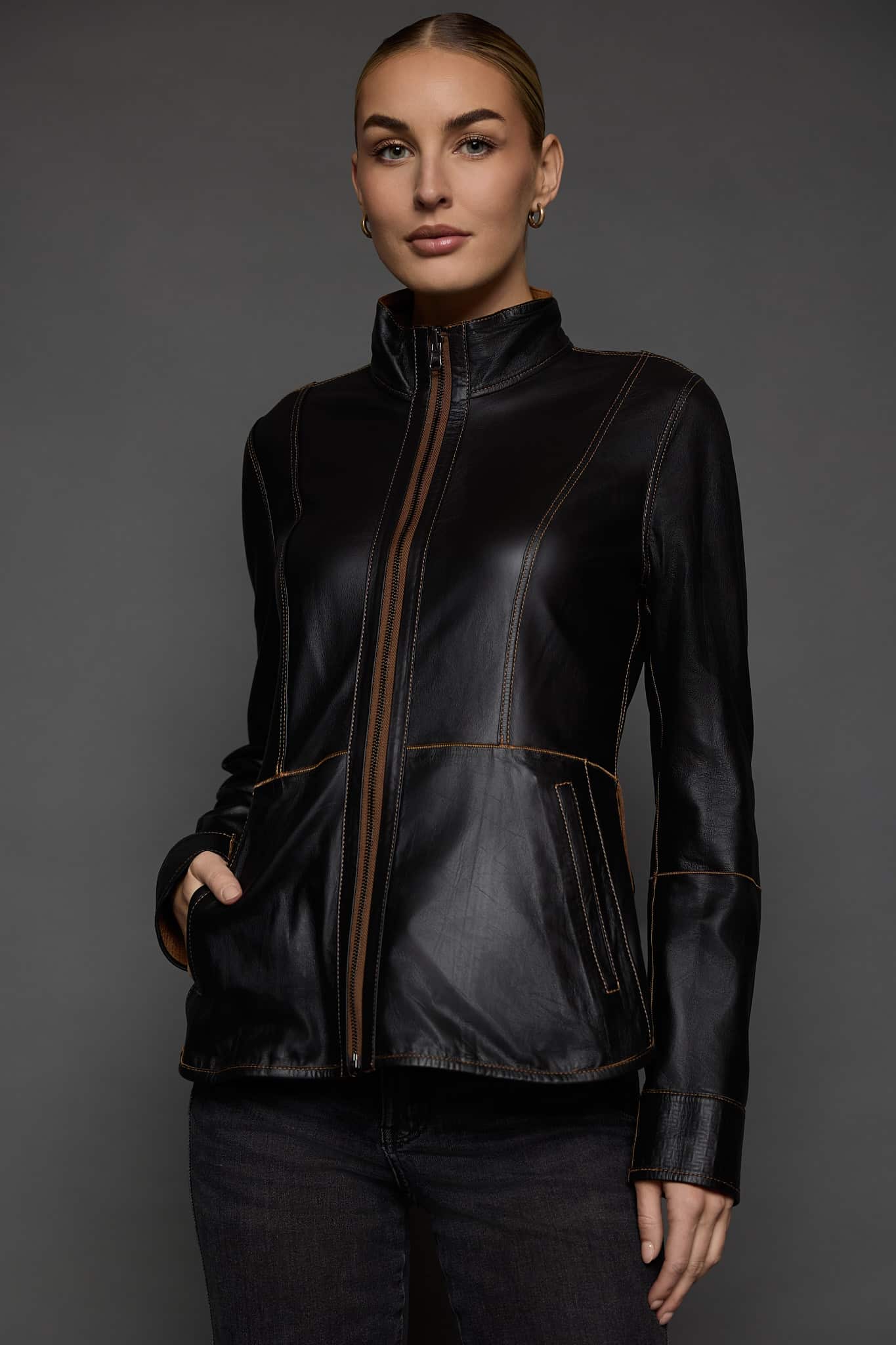 IMANI SNUFF BLACK JACKET REV FRONT woman in a black jacket against a grey background