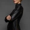 IMANI SNUFF BLACK JACKET REV SIDE the side of a woman in a black jacket against a grey background