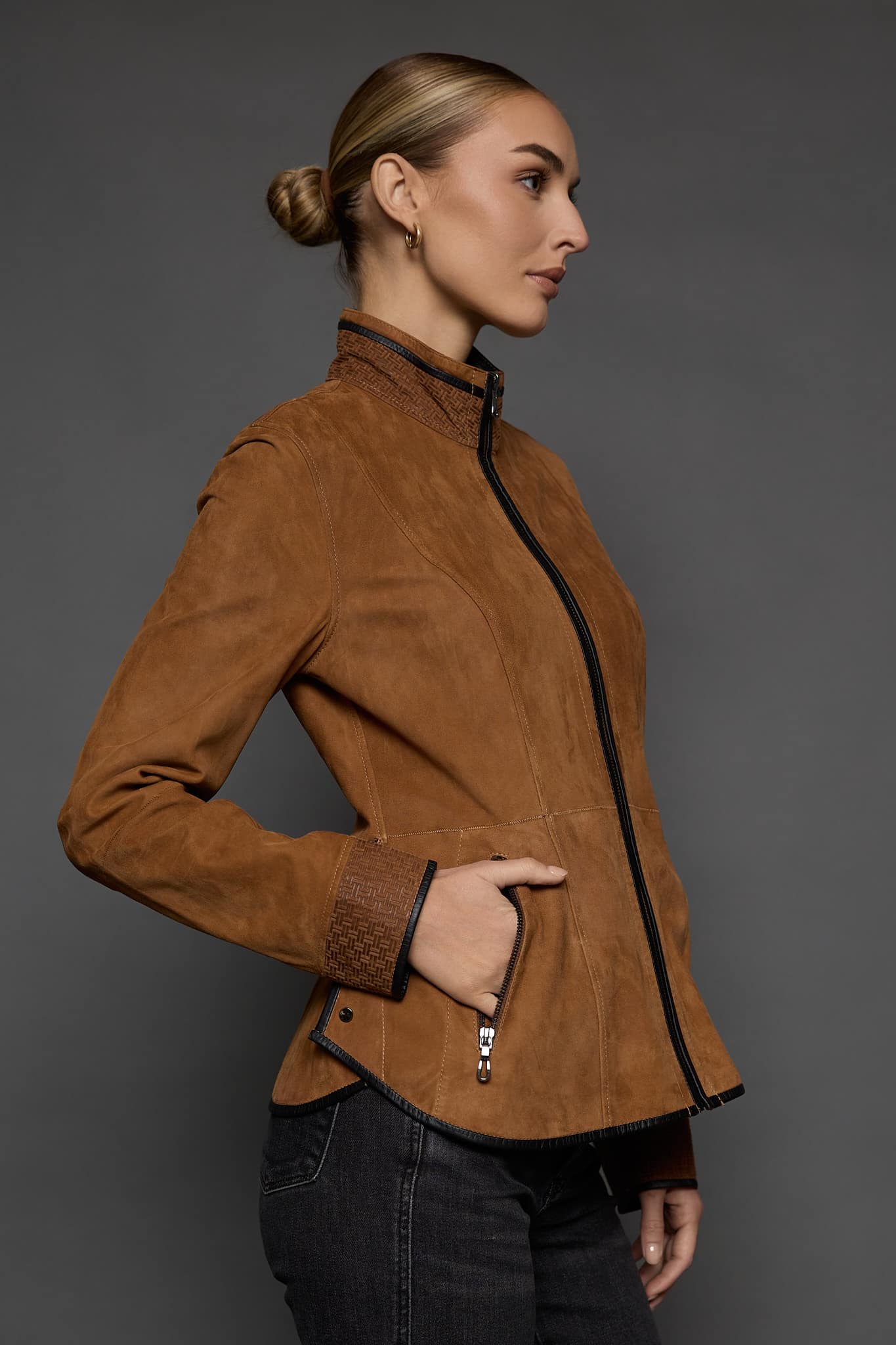 IMANI SNUFF BLACK JACKET SIDE the side of a woman in a tan jacket against a grey background