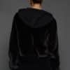 the back of a woman in a black jacket against a white background