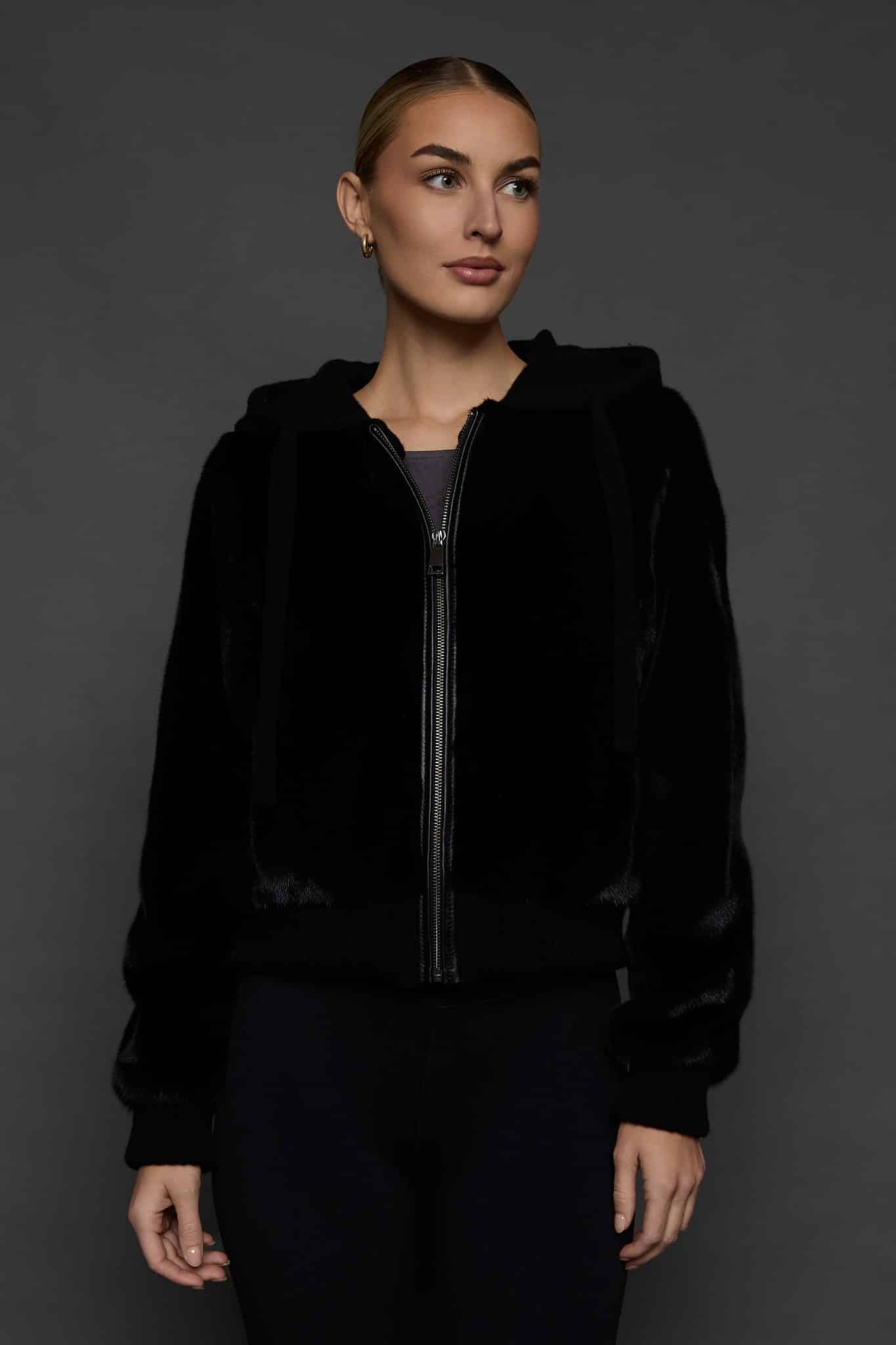 woman in a black jacket against a white background