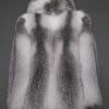 the back of a woman in a white grey fur coat against a grey background