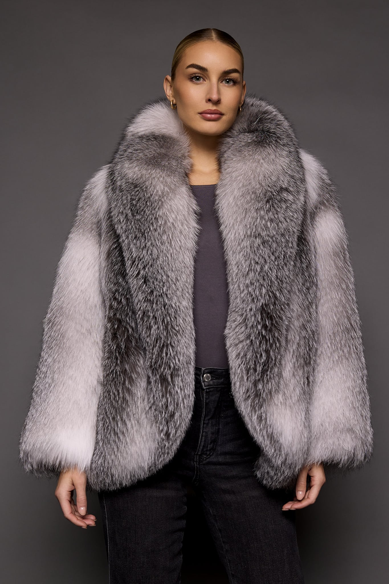 woman in a white grey fur coat against a grey background