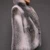 the side of a woman in a white grey fur coat against a grey background