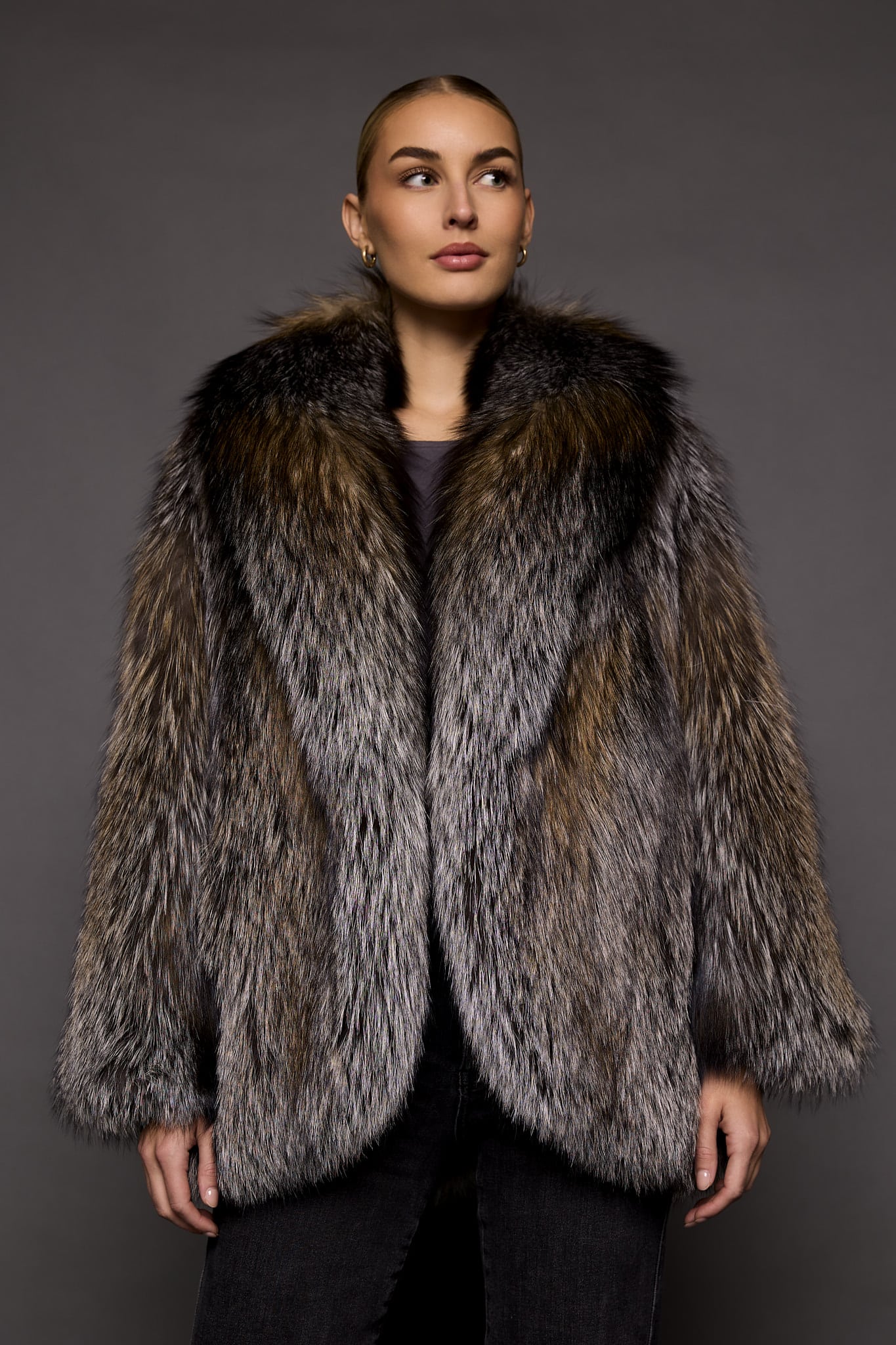 woman in a brown fur coat against a grey background