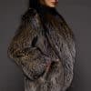 the side of a woman in a brown fur coat against a grey background