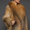 the side of a a woman in a red fur coat against a grey background