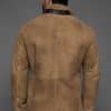 the back of a man in a tan coat against a grey background