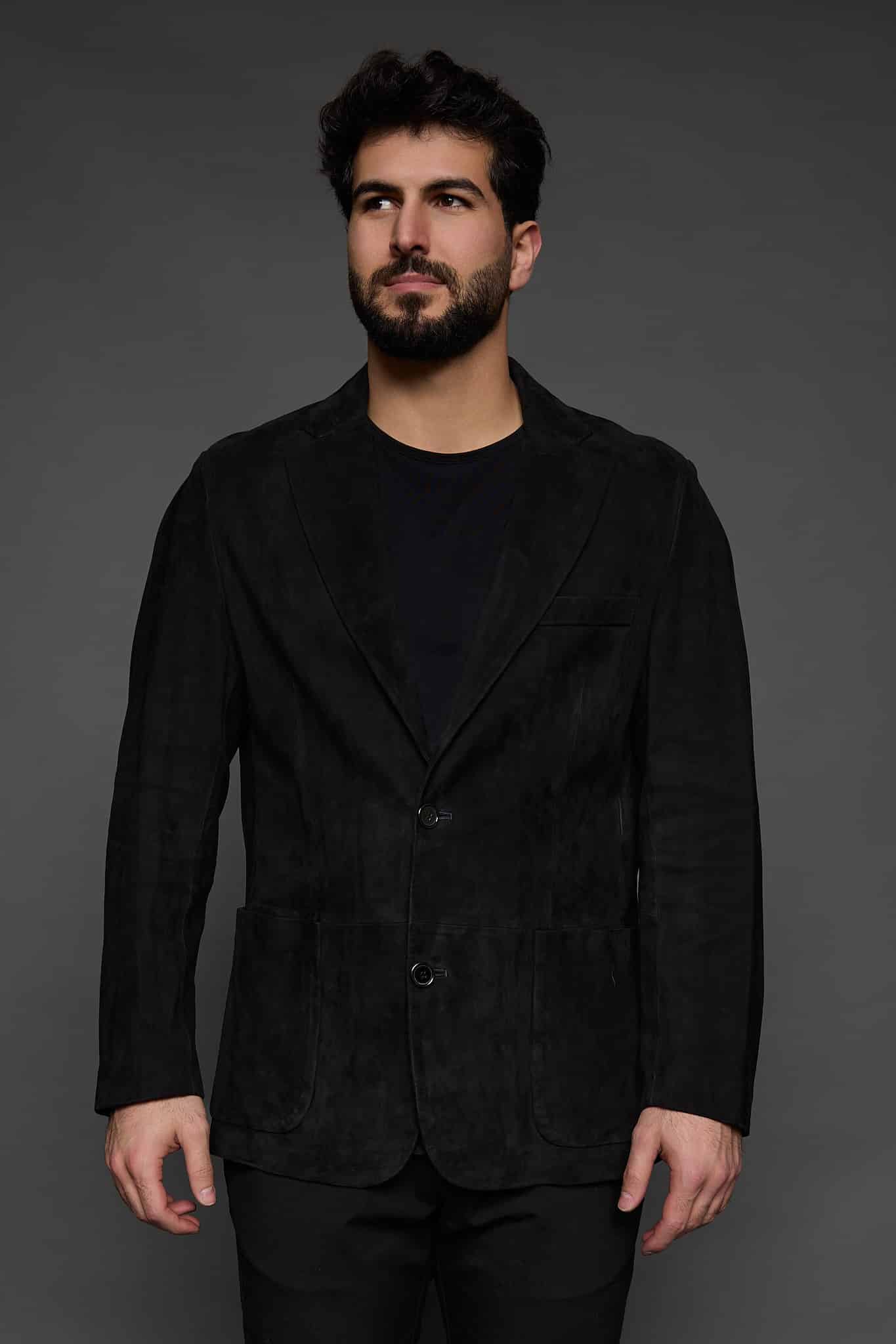 man in a black coat against a grey background