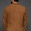 the back of a man in a tan coat against a grey background