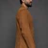 the side of a man in a tan coat against a grey background