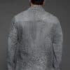 the back of a man in a grey jacket against a grey background