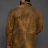 the back of a man in a brown jacket against a grey background